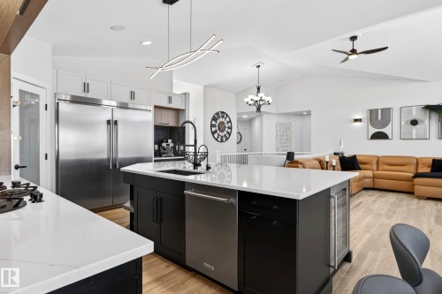 Open-concept kitchen featuring an oversized island with white countertops, integrated sink, and dishwasher - 324 Cutts Crest, Edmonton, AB - Indoor Photo Showing Kitchen With Upgraded Kitchen