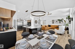 Open-concept living space featuring wood-finish flooring, vaulted ceilings, and recessed lighting - 