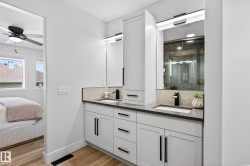 Dual vanity with dark countertops and white cabinetry - 