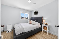 Bedroom featuring light wood-finish flooring, a bright window, and light-toned walls - 