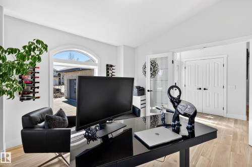 Bright interior space featuring an arched window, light wood-finish flooring, and white paneled doors - 324 Cutts Crest, Edmonton, AB - Indoor