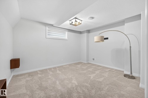 Recessed room featuring light-colored patterned carpeting, white baseboards, and a single window with horizontal blinds - 324 Cutts Crest, Edmonton, AB - Indoor