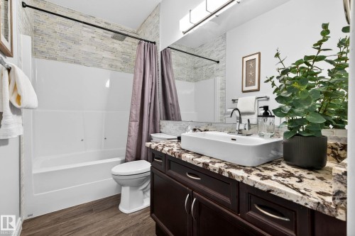 Bathroom with a dark wood-finish vanity, a rectangular vessel sink, and a patterned stone countertop - 324 Cutts Crest, Edmonton, AB - Indoor Photo Showing Bathroom