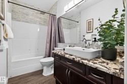 Bathroom with a dark wood-finish vanity, a rectangular vessel sink, and a patterned stone countertop - 