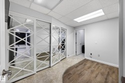 Mirrored sliding closet doors with decorative white framing, wood-finish flooring, and a drop ceiling with recessed lighting - 