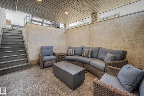 Private outdoor patio featuring a textured stucco wall, concrete flooring, and a covered ceiling with recessed lighting - 324 Cutts Crest, Edmonton, AB -  With Exterior