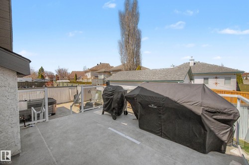 Spacious concrete deck with glass panel railings and a built-in hot tub - 324 Cutts Crest, Edmonton, AB - Outdoor