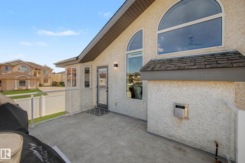 Exterior patio featuring a concrete surface, glass panel railing, and a secure access door - 324 Cutts Crest, Edmonton, AB - Outdoor With Exterior