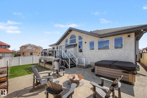 Stucco exterior with multiple large windows and an arched window design - 324 Cutts Crest, Edmonton, AB - Outdoor With Deck Patio Veranda With Exterior