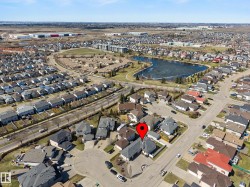 Aerial overview of a residential neighborhood featuring detached homes with grey shingle roofs - 