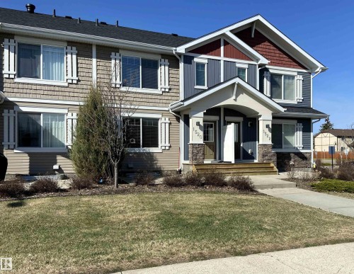 Modern townhome exterior featuring multi-toned siding, decorative window shutters, and a covered entry with stone accents - 1520 105 Street, Edmonton, AB - Outdoor With Facade