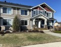 Modern townhome exterior featuring multi-toned siding, decorative window shutters, and a covered entry with stone accents - 1520 105 Street, Edmonton, AB  - Outdoor With Facade 