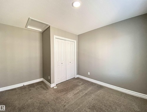 Interior room featuring neutral wall color, plush carpet, white trim, and a bi-fold closet door - 1520 105 Street, Edmonton, AB - Indoor Photo Showing Other Room