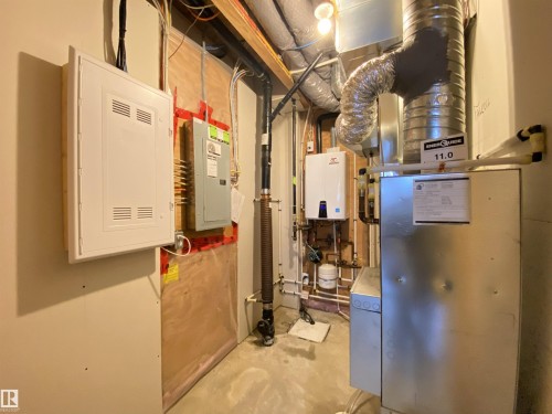 Utility area featuring an electrical panel, water heater, and furnace - 1520 105 Street, Edmonton, AB - Indoor Photo Showing Basement
