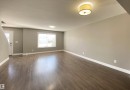 Spacious main living area featuring wood-finish flooring, neutral wall tones, and white trim - 1520 105 Street, Edmonton, AB  - Indoor Photo Showing Other Room 