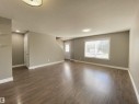 Open-concept living area featuring wood-finish flooring, neutral wall tones, and white baseboards - 1520 105 Street, Edmonton, AB  - Indoor 