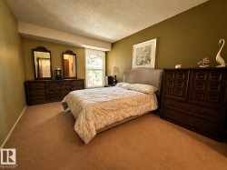 Spacious room featuring broadloom carpeting and a window with vertical blinds - 