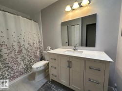 Bathroom featuring a single vanity with a white countertop, an undermount sink, and a chrome faucet - 