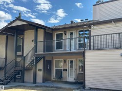 Exterior featuring horizontal siding, multiple balconies with dark railings, and exterior staircases - 