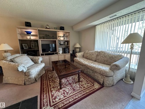 Integrated entertainment center with glass-front display cabinets and ambient lighting - 2071 Saddleback Road, Edmonton, AB - Indoor Photo Showing Living Room