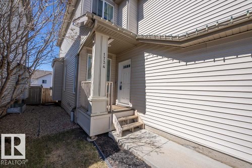 Front entrance featuring a covered porch, white paneled door, and wood stairs - 1734 63A Street, Edmonton, AB - Outdoor