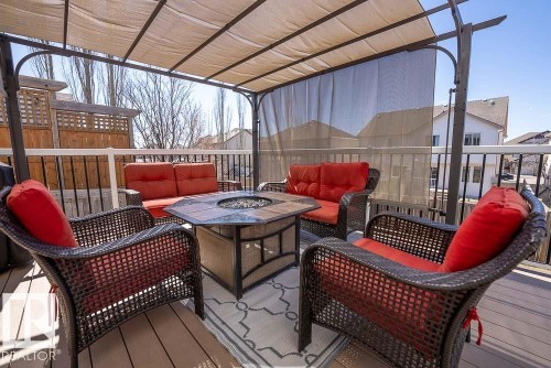 Expansive outdoor deck featuring composite decking, a metal pergola with a retractable fabric canopy, a decorative privacy screen, and a perimeter railing with white top rail and black balusters - 1734 63A Street, Edmonton, AB - Outdoor With Deck Patio Veranda With Exterior