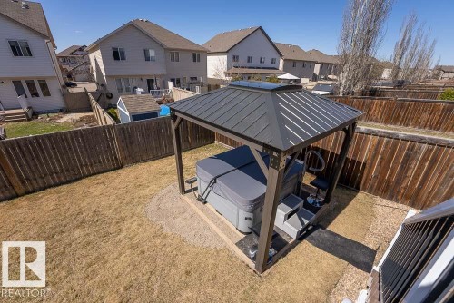 Backyard featuring a gazebo with a dark metal roof, a hot tub with a gray cover, and a surrounding privacy fence - 1734 63A Street, Edmonton, AB - Outdoor With Deck Patio Veranda