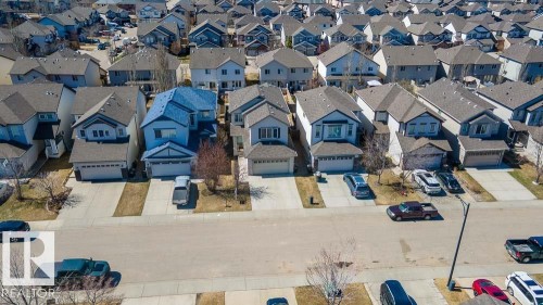 Two-story residence featuring a distinctive blue roof, light-colored siding, and an attached two-car garage - 1734 63A Street, Edmonton, AB - Outdoor