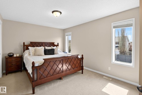 Carpeted bedroom with neutral wall tones and a ceiling-mounted light fixture - 7723 7A Avenue, Edmonton, AB - Indoor Photo Showing Bedroom