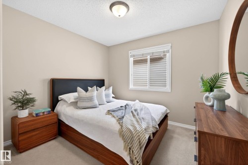 Neutral-toned walls complement a single window with blinds and a ceiling-mounted light fixture - 7723 7A Avenue, Edmonton, AB - Indoor Photo Showing Bedroom