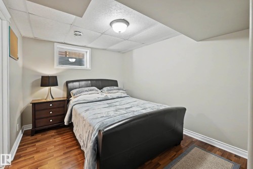 Bedroom featuring wood-finish flooring, white baseboards, and neutral wall tones - 7723 7A Avenue, Edmonton, AB - Indoor Photo Showing Bedroom