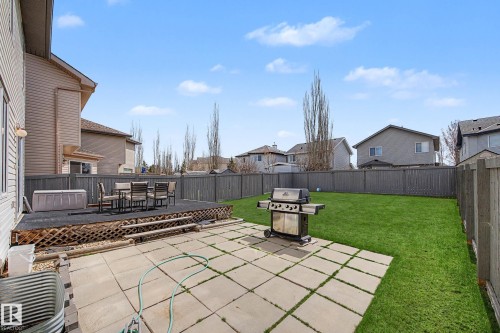 Expansive backyard featuring a manicured lawn, full privacy fencing, and a multi-level outdoor living space - 7723 7A Avenue, Edmonton, AB - Outdoor With Deck Patio Veranda