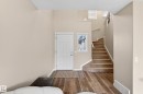Entryway featuring a paneled door with an adjacent sidelight window, wood-finish flooring, and a carpeted staircase with white trim - 7723 7A Avenue, Edmonton, AB  - Indoor Photo Showing Other Room 