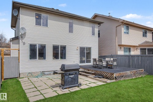 Expansive backyard featuring a manicured lawn, a large raised deck, a patio with square pavers, and a privacy fence - 7723 7A Avenue, Edmonton, AB - Outdoor With Deck Patio Veranda With Exterior