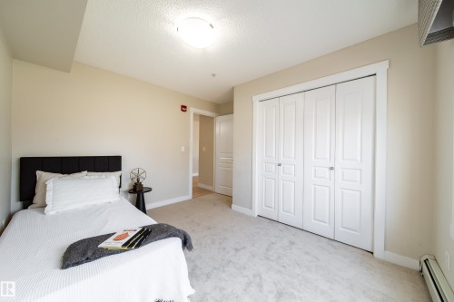 Light-toned wall paint and matching trim complement the soft carpeting - 117 2229 44 Avenue, Edmonton, AB - Indoor Photo Showing Bedroom