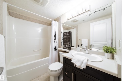 Bathroom featuring a dark wood-finish vanity with a light-toned countertop and an integrated sink - 117 2229 44 Avenue, Edmonton, AB - Indoor Photo Showing Bathroom