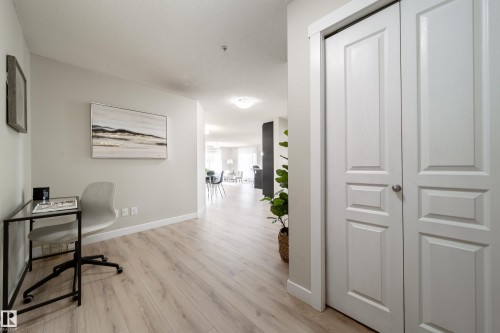 Light wood-finish flooring extending through an open-concept living area - 117 2229 44 Avenue, Edmonton, AB - Indoor