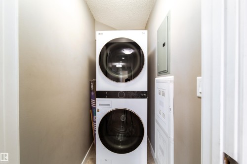 Stackable washer and dryer unit in a dedicated utility alcove - 117 2229 44 Avenue, Edmonton, AB - Indoor Photo Showing Laundry Room