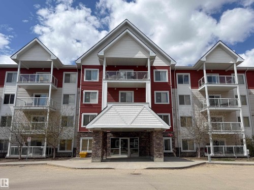 Multi-story residential building featuring red and white siding - 117 2229 44 Avenue, Edmonton, AB - Outdoor With Balcony With Facade