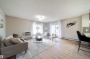 Open-concept living area featuring light wood-finish flooring, light neutral wall paint, and a sliding glass door leading to an outdoor space - 117 2229 44 Avenue, Edmonton, AB  - Indoor Photo Showing Living Room 