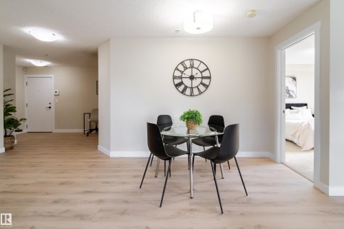 Light wood-finish flooring extends through the space, complemented by a white baseboard trim - 117 2229 44 Avenue, Edmonton, AB - Indoor Photo Showing Dining Room