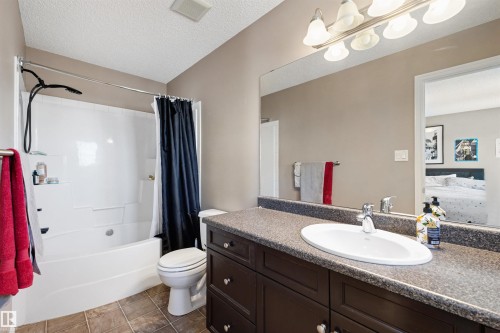 Bathroom featuring a white integrated tub and shower unit with a handheld showerhead - 6115 18 Avenue, Edmonton, AB - Indoor Photo Showing Bathroom