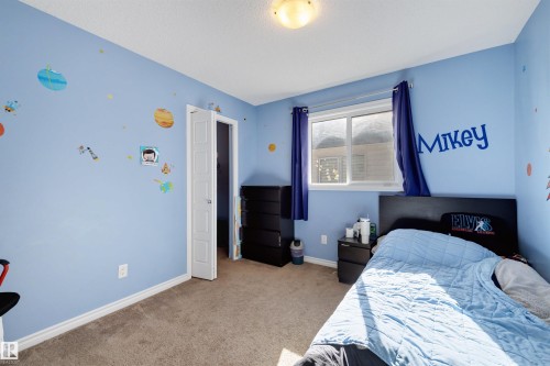 Room featuring light blue walls, a single window with dark blue curtains, and a ceiling-mounted light fixture - 6115 18 Avenue, Edmonton, AB - Indoor Photo Showing Bedroom