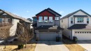 Contemporary two-story residence featuring a two-car garage with overhead door, a concrete driveway, and siding exterior with red and dark gray accents - 6115 18 Avenue, Edmonton, AB  - Outdoor With Facade 