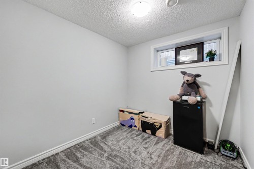 Light gray walls with a patterned carpet flooring - 6115 18 Avenue, Edmonton, AB - Indoor Photo Showing Other Room