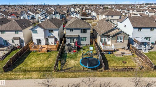 Expansive backyard featuring a manicured lawn, a chain-link fence, and a wooden deck with railing - 6115 18 Avenue, Edmonton, AB - Outdoor