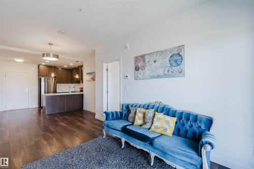 Open concept living area featuring dark wood-finish flooring, white walls, and recessed lighting - 205 1316 Windermere Way, Edmonton, AB - Indoor