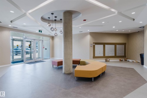 Lobby area featuring multi-toned flooring with a geometric pattern, glass entry doors, and recessed lighting - 205 1316 Windermere Way, Edmonton, AB - Indoor Photo Showing Other Room