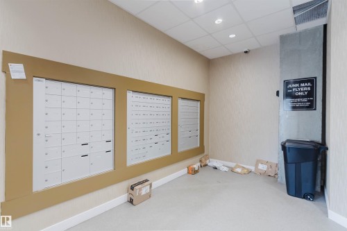 Mailbox area featuring multiple secure mail slots within a framed enclosure and recessed lighting - 205 1316 Windermere Way, Edmonton, AB - Indoor Photo Showing Other Room