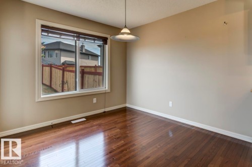 Hardwood-finish flooring with a semi-gloss sheen - 119 Rue Monique, Beaumont, AB - Indoor Photo Showing Other Room